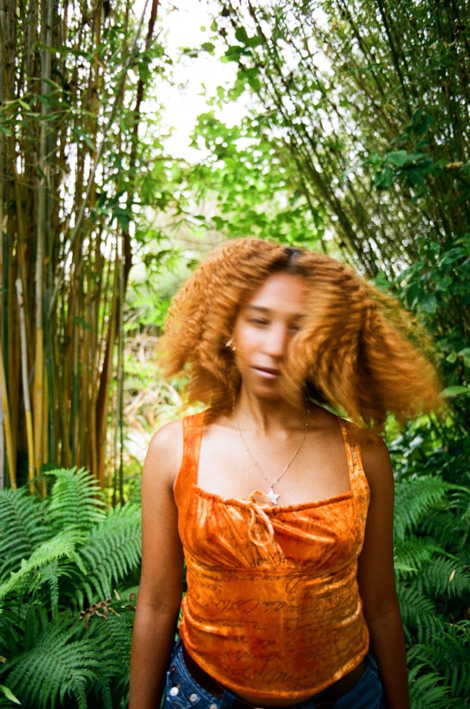 Nicole Hernandez mid hair-flip in a bamboo grove